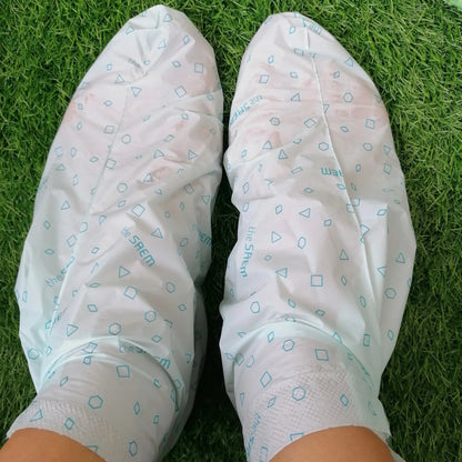 White gloves with blue patterns on a green grass background